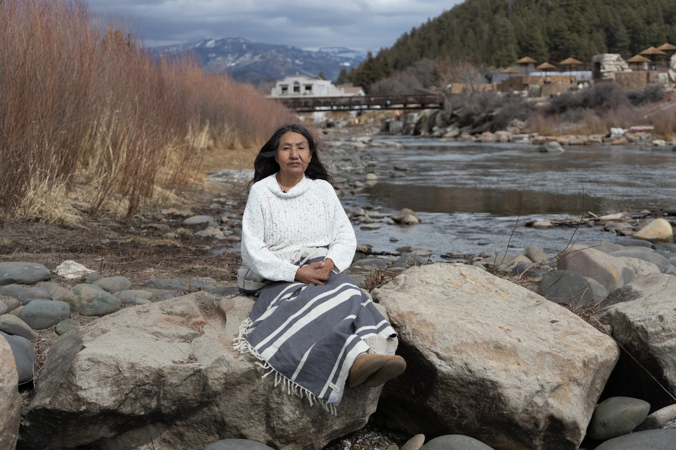 Cassandra Atencio sits by the San Juan River in Pagosa Springs. Photo: Amanda Horvath, Rocky Mountain PBS