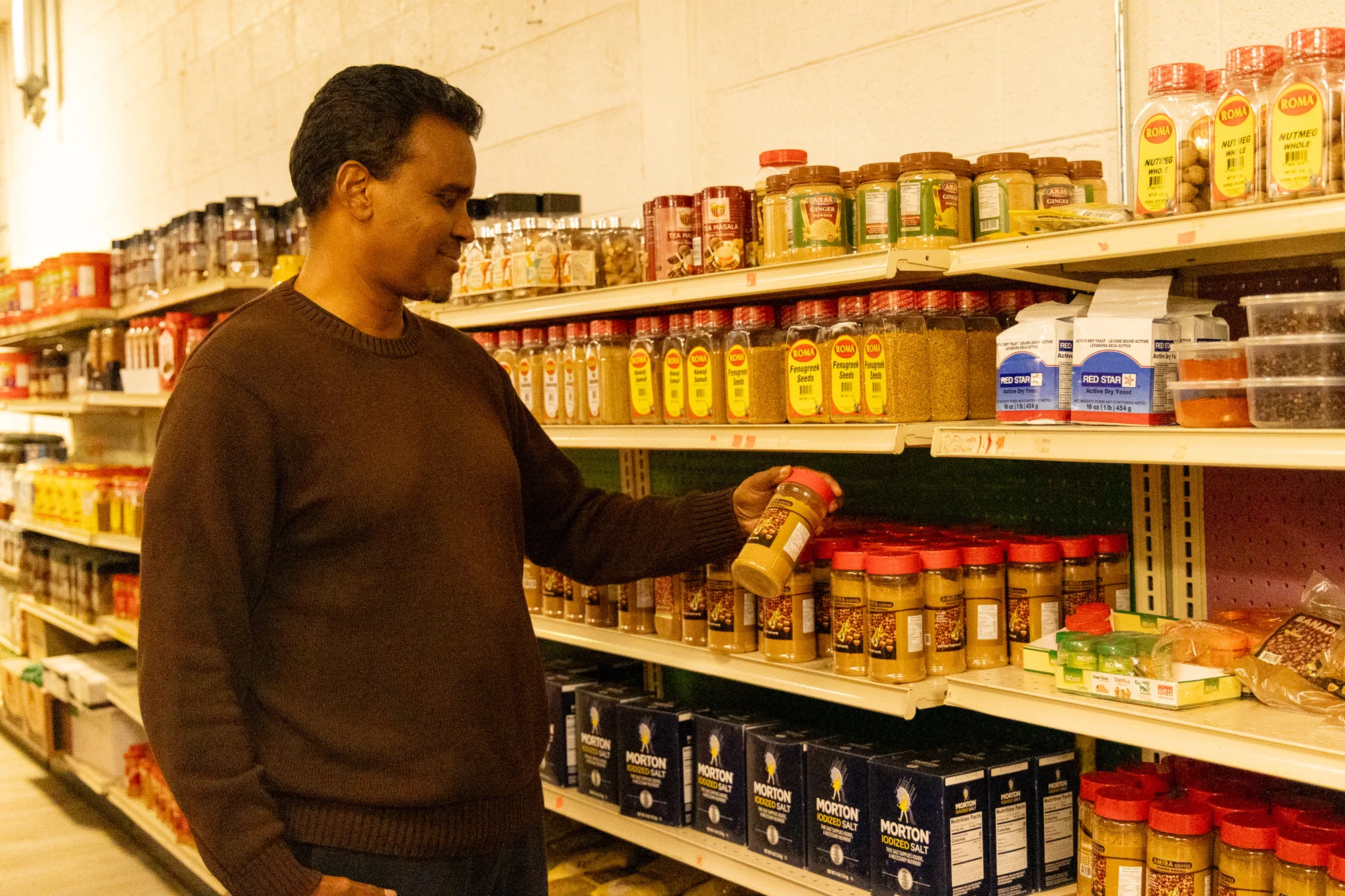 Ali Elmi looks at Somali coffee from the shelf at Midnimo Grocery Store. Photo: Priya Shahi, Rocky Mountain PBS