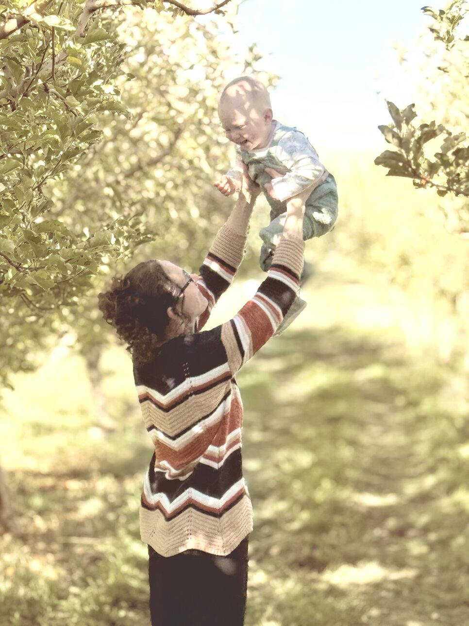 Ashtonn holds Astrid in an apple orchard