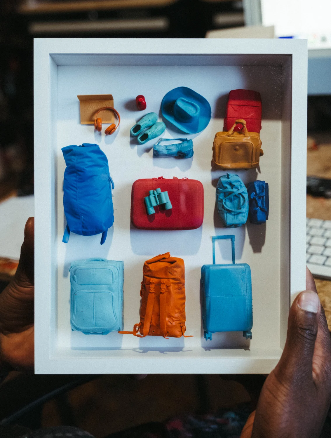 Evans 3D printed the luggage and items that he received from donations, framing them in these unique compositions that he's selling. Photo: Peter Vo, Rocky Mountain PBS