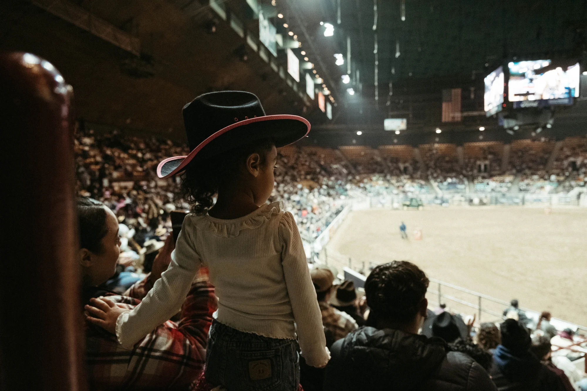 A little girl watches the rodeo from the stands. Photos: Peter Vo, Rocky Mountain PBS