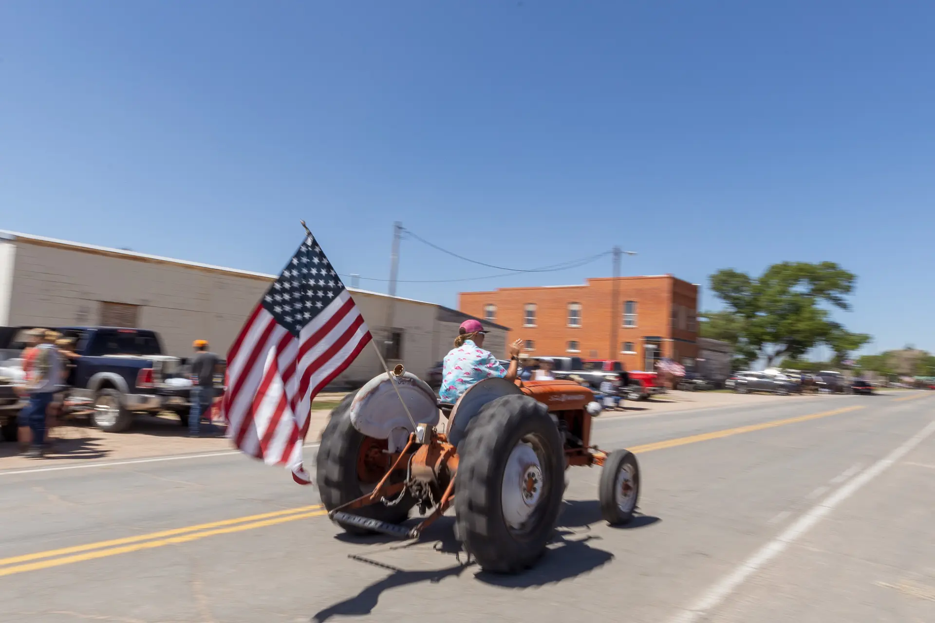 Tractors parade down main street during a parade before the rodeo.