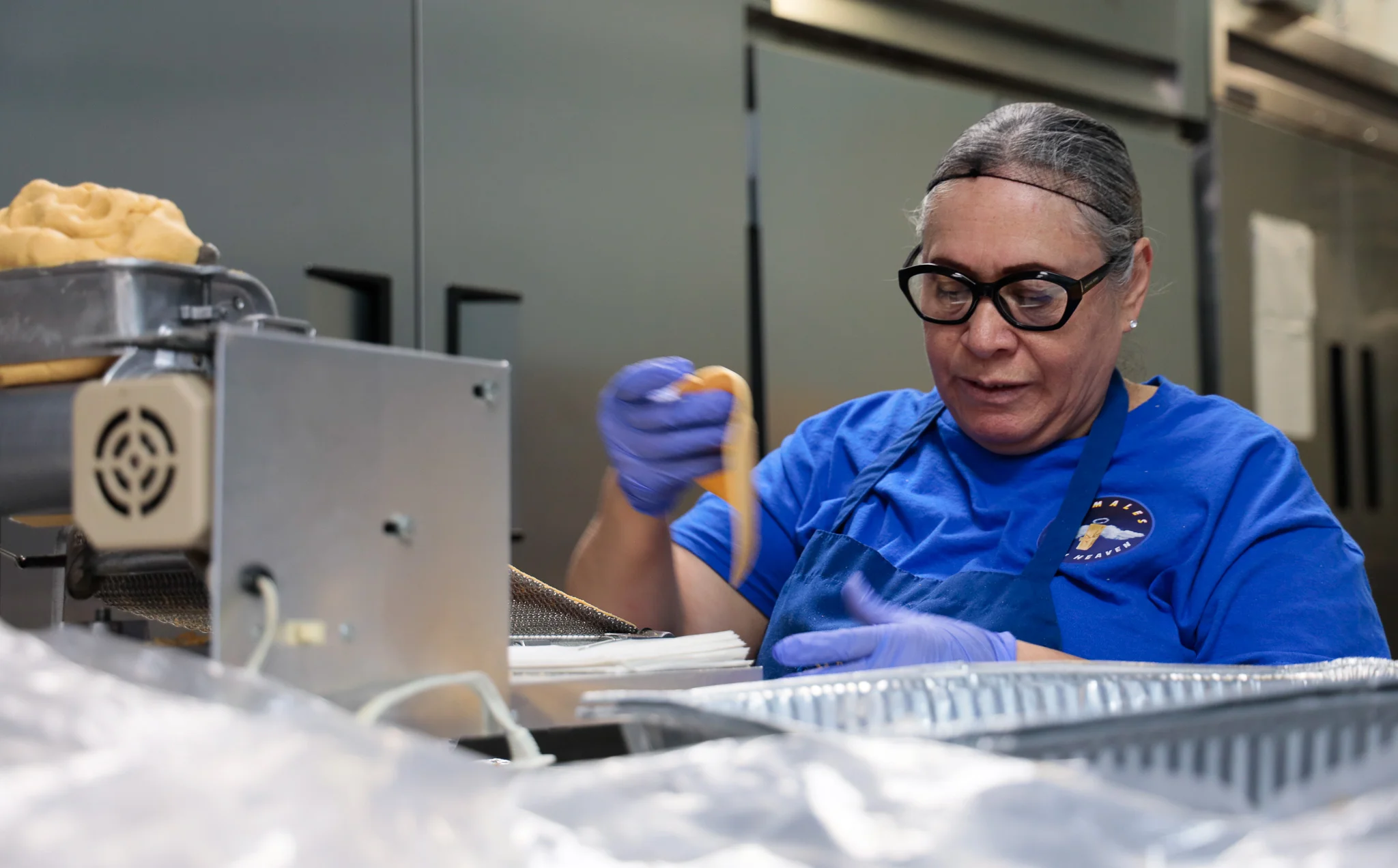 Rosalva Rocha uses a modified tortilla press to prepare the masa for tamales. Photo: Cormac McCrimmon, Rocky Mountain PBS