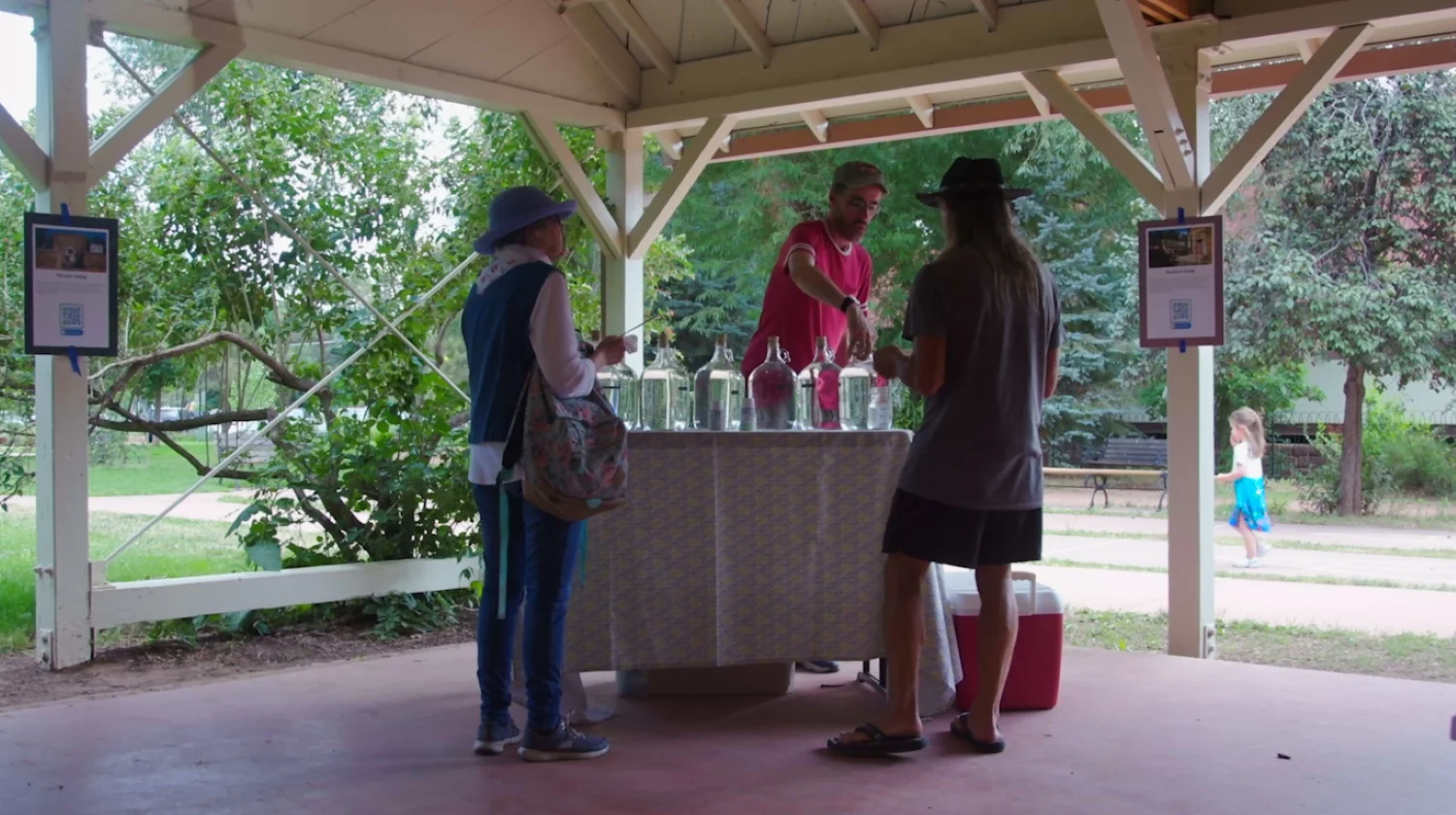 Trask (center) offers samples of the springs to curious tasters.  Photo: Chase McCleary, Rocky Mountain PBS