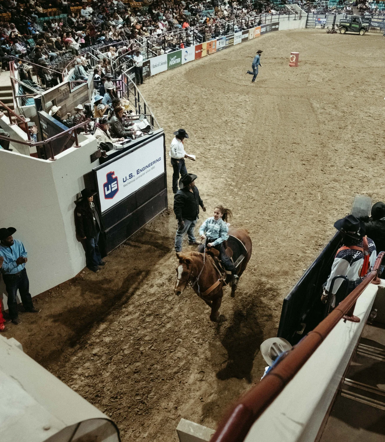 A girl rides out of the arena after completing the barrel racing event.