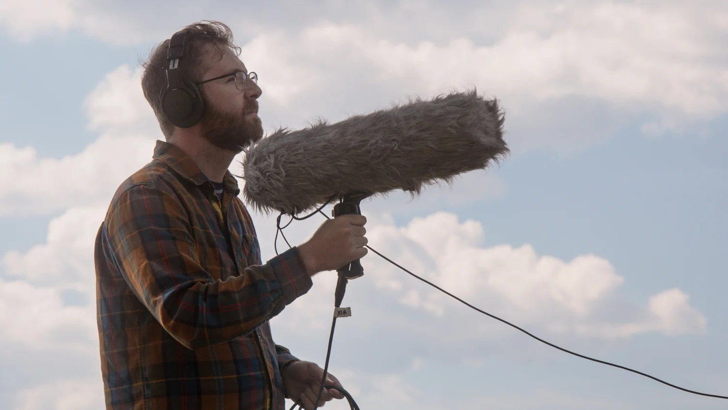 Garrison Gerard records natural sound using a shotgun microphone at Rocky Mountain National Park. Photo: Cormac McCrimmon, Rocky Mountain PBS