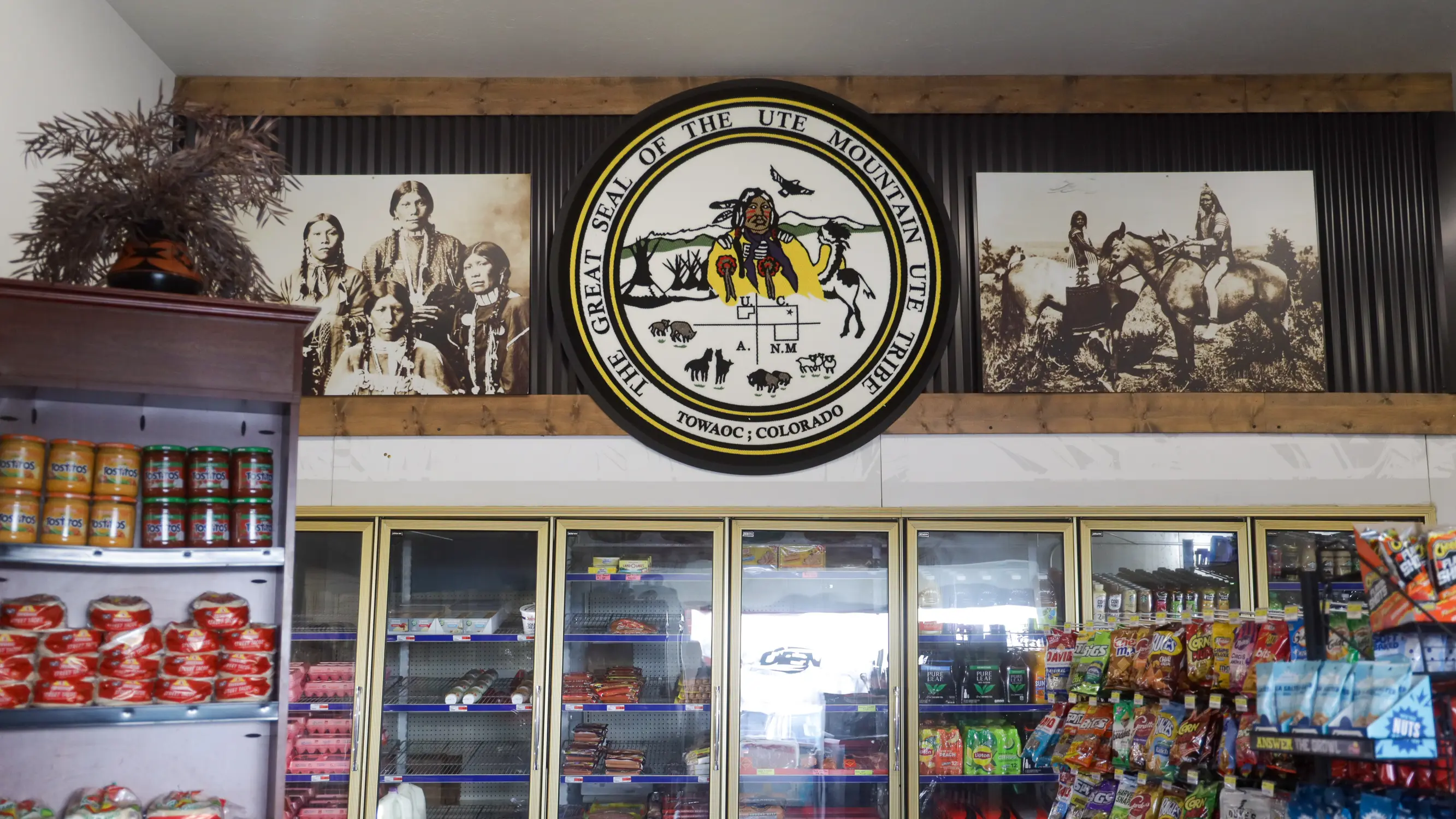 The store's decor includes a large tribal logo and archival photos of tribal members. Photo: Ziyi Xu, Rocky Mountain PBS