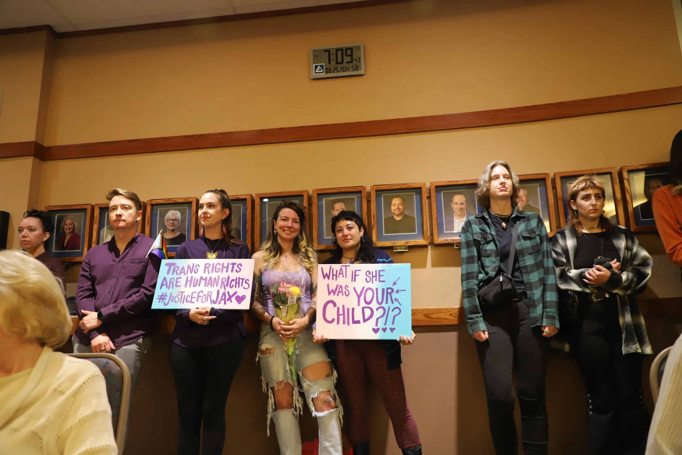 Advocates at the council meeting held signs in support of Gratton. Photo: Alec Berg, Rocky Mountain PBS