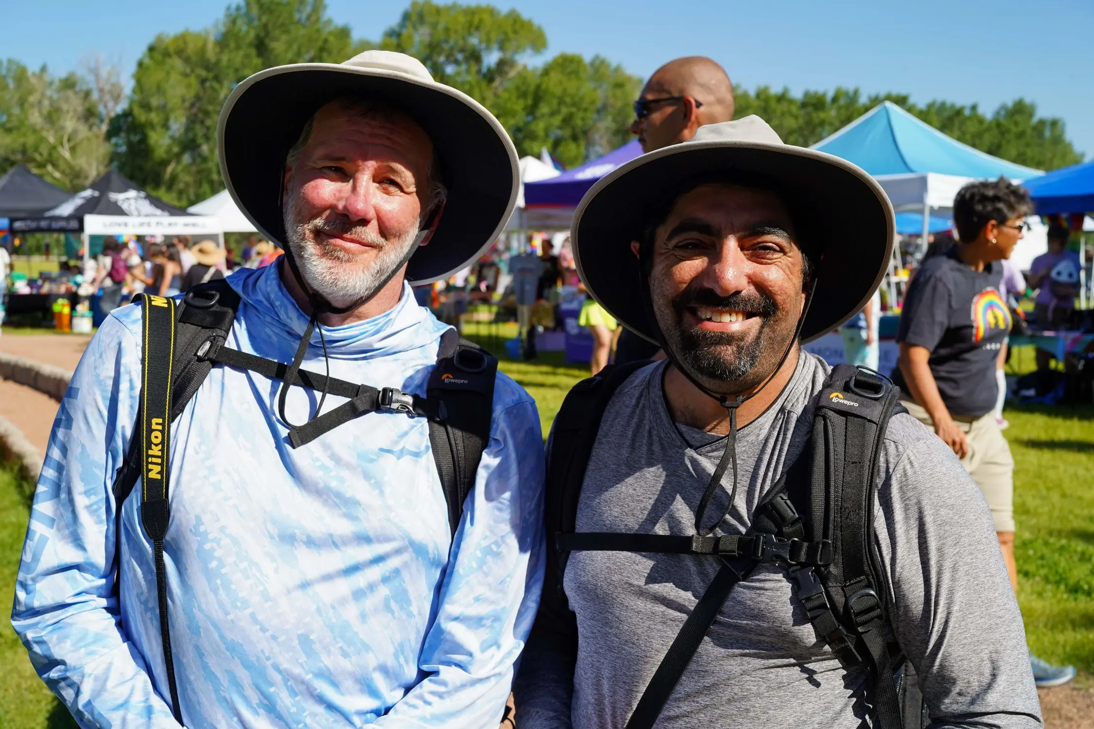 Shaun Seela, left, and Scott Pedram pose for a photo at Montrose Pride, which they decided to visit on a whim, after seeing a banner downtown. They were in western Colorado to hike at Black Canyon of the Gunnison National Park, 20 minutes outside of Montrose. Photo: Joshua Vorse, Rocky Mountain PBS