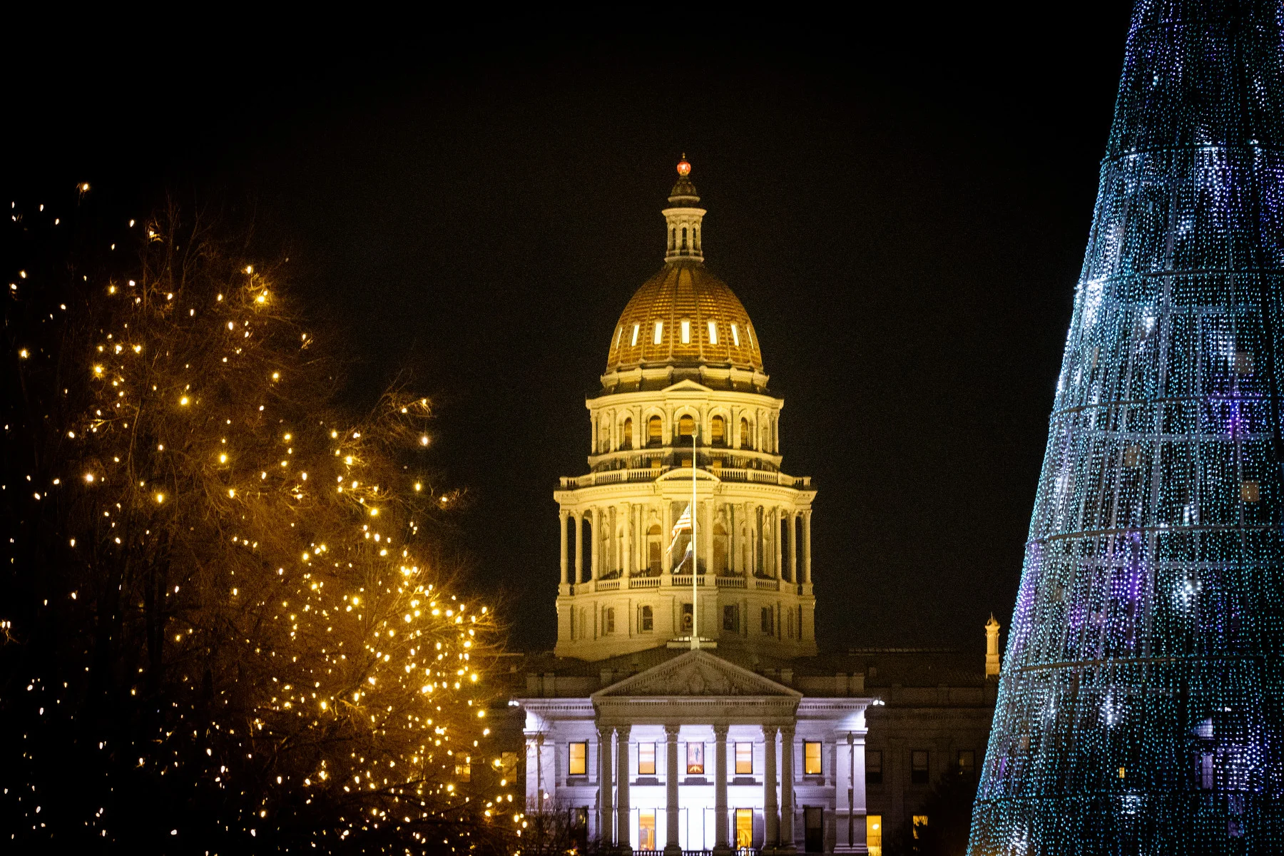 Despite small Republican gains in the House, Democrats will still hold strong majorities in both the House and the Senate when the legislature convenes Wednesday. Here, the Colorado Capitol is seen from Denver’s City and County Building, framed by holiday lights in Civic Center Park, Dec. 18, 2023. Photo: Hart Van Denburg, CPR News