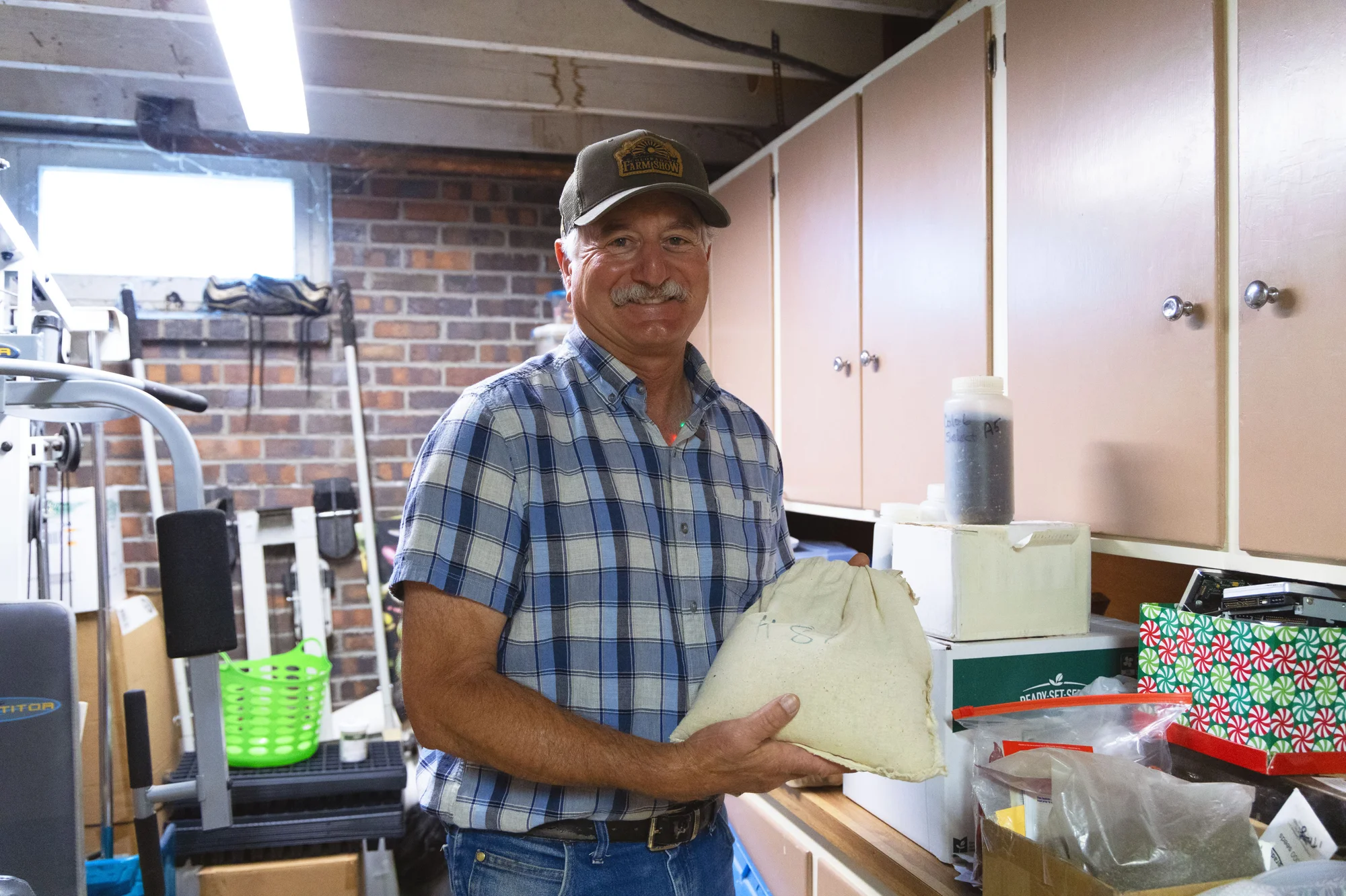 Bartolo poses with his uncle’s original bag of seeds, labeled “‘87” for 1987. Photo: Chase McCleary, Rocky Mountain PBS