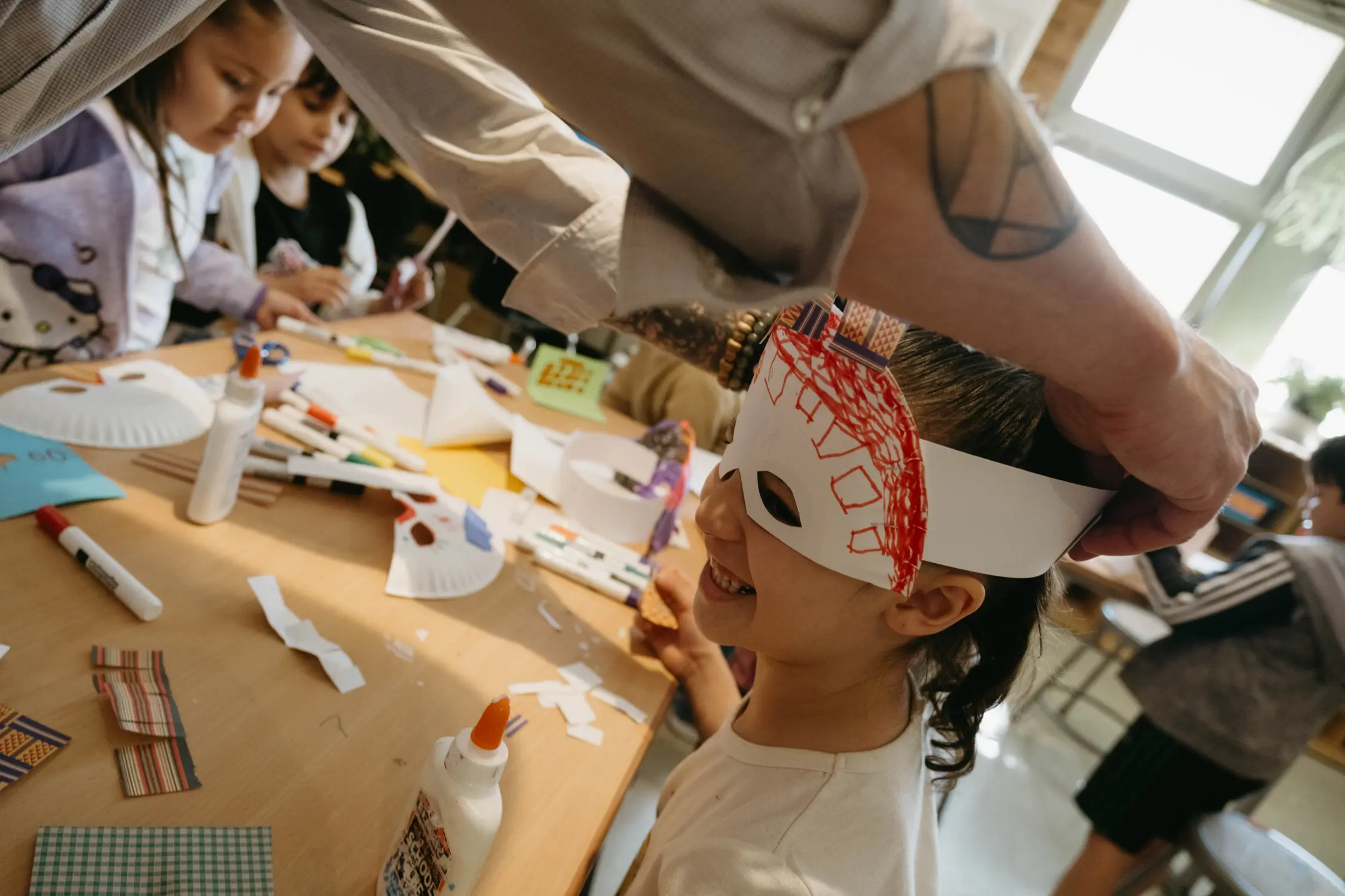  Quenzer puts a mask on a student for the “Wild Rumpus”. Photo: Peter Vo, Rocky Mountain PBS
