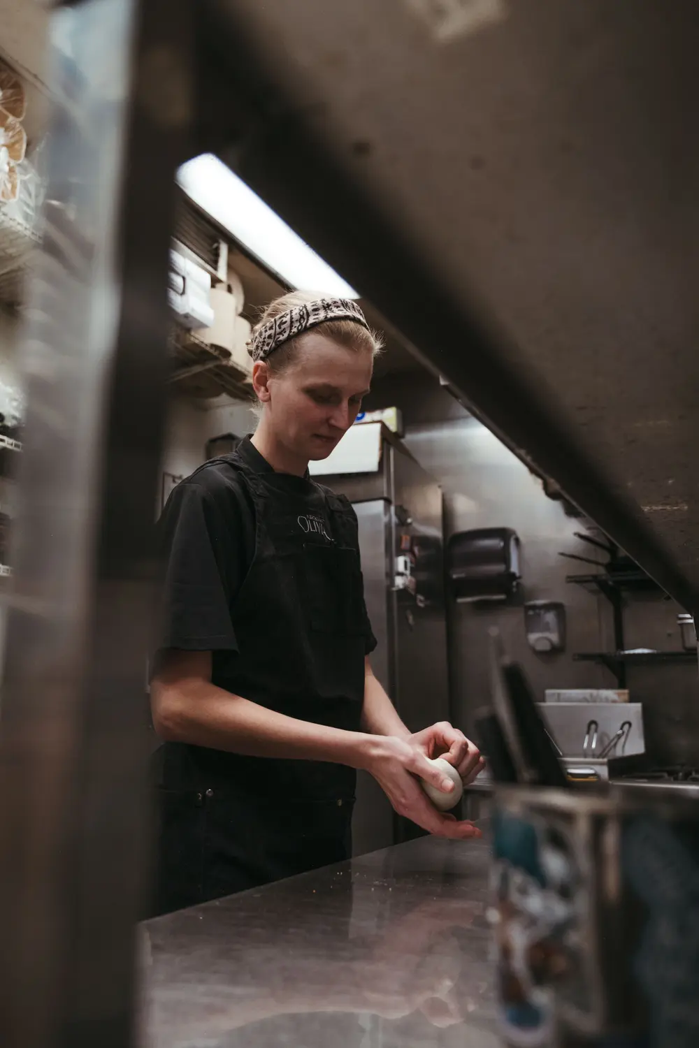 Addison Bollaert shapes focaccia at Restaurant Olivia. Photo: Peter Vo, Rocky Mountain PBS