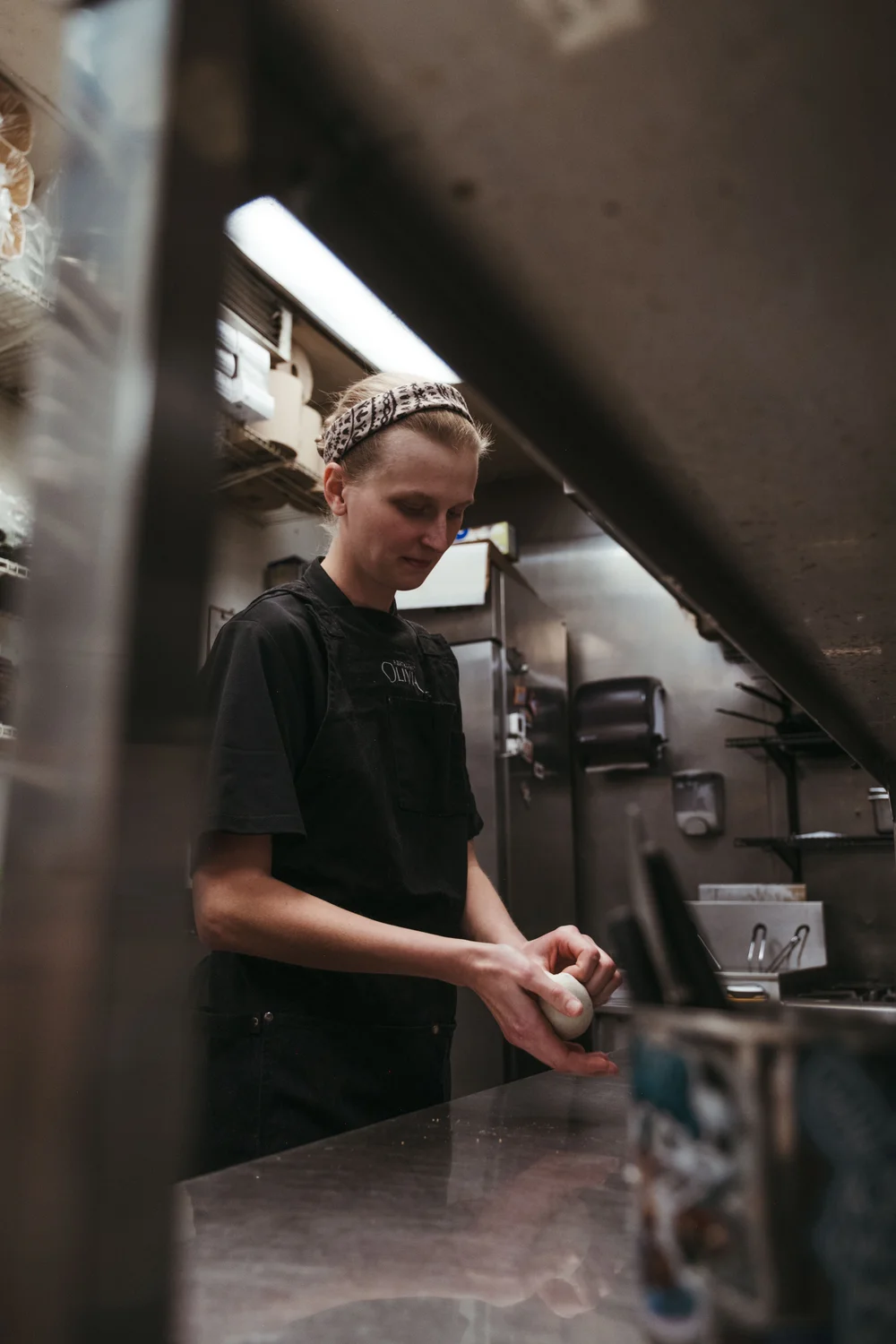 Addison Bollaert shapes focaccia at Restaurant Olivia. Photo: Peter Vo, Rocky Mountain PBS