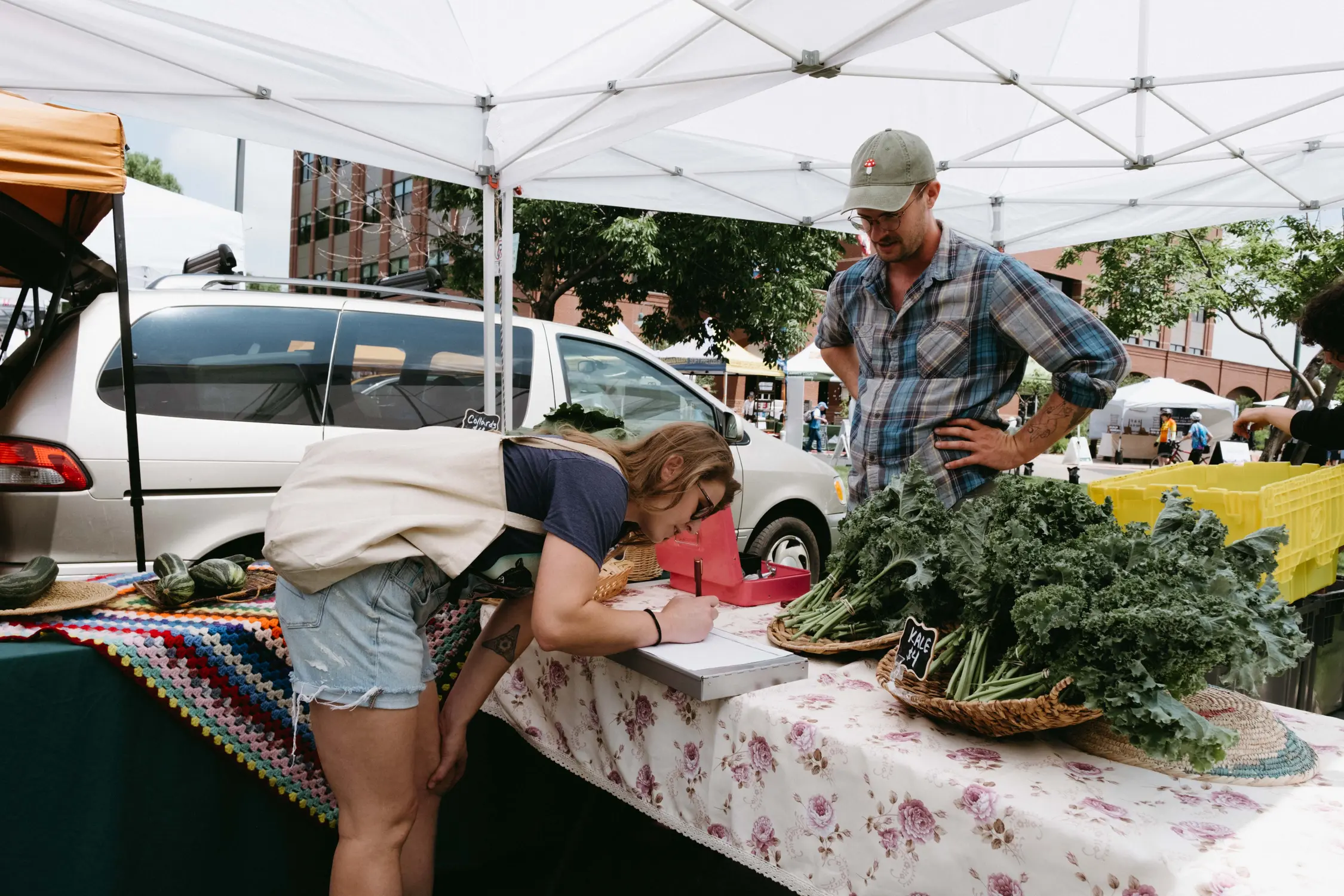 Carli Donoghue writes down the inventory for produce that vendors are selling to the food bank as part of the "Veg Out" program. Photo: Peter Vo, Rocky Mountain PBS