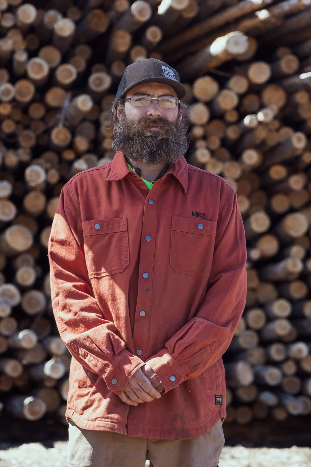 Mike Brath, the mill's manager, stands in front of a pile of beetle-kill logs that will be used for buck and rail fencing.