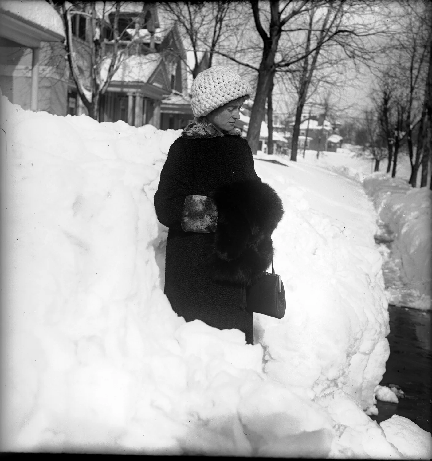 A woman in a fur coat stands on Clarkson Street in Denver following the December 1913 blizzard. Photo: Robert B. Rockwell via Denver Public Library