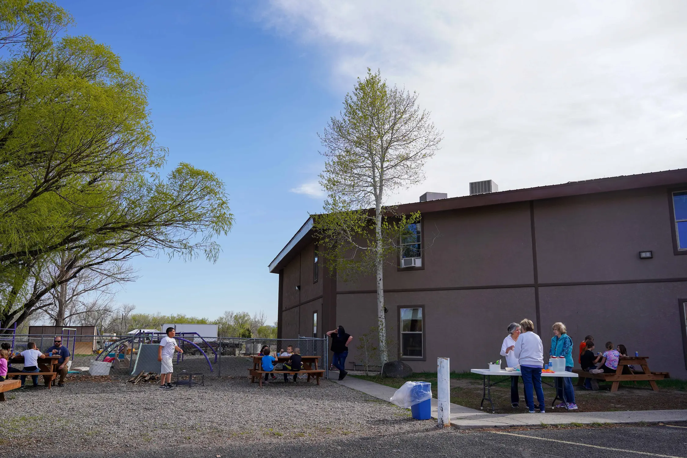 Kids and Hub volunteers enjoy sun and a snack of PB&J, oranges, and chips and salsa in the backyard of the Clifton Assembly of God church. Photo: Joshua Vorse, Rocky Mountain PBS