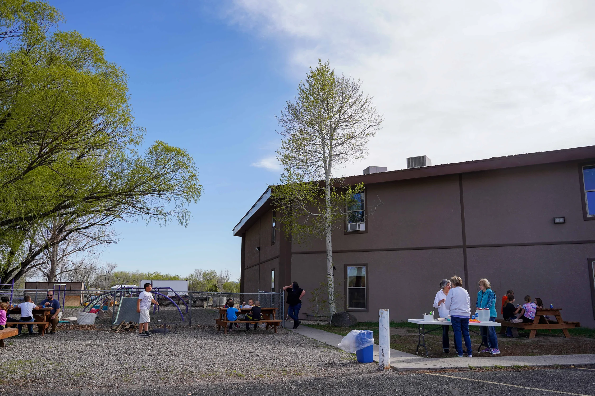 Kids and Hub volunteers enjoy sun and a snack of PB&J, oranges, and chips and salsa in the backyard of the Clifton Assembly of God church. Photo: Joshua Vorse, Rocky Mountain PBS