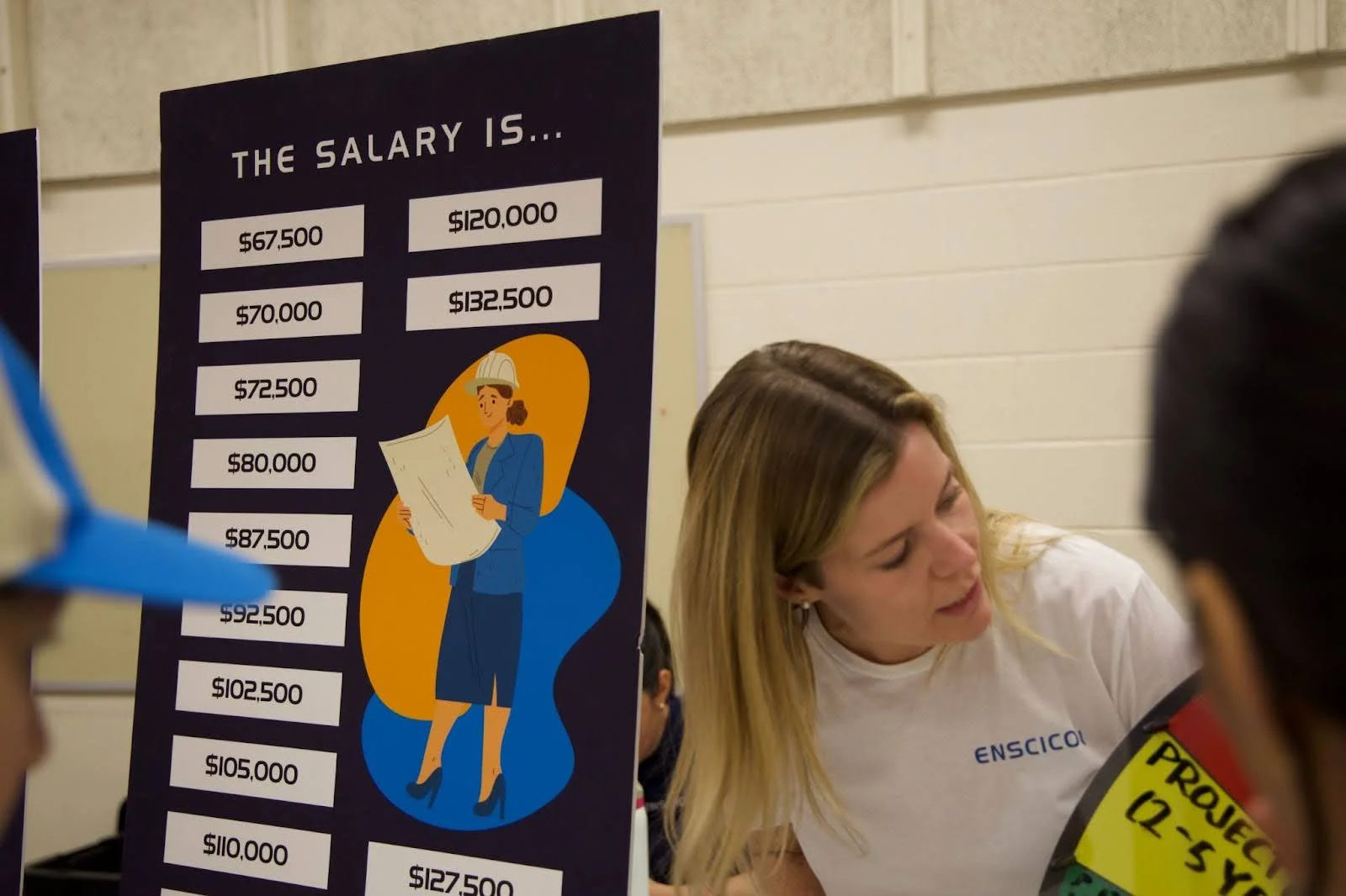 A career day exhibitor surprises girls with how much money they could make in the construction industry. Photo: Chase McCleary, Rocky Mountain PBS