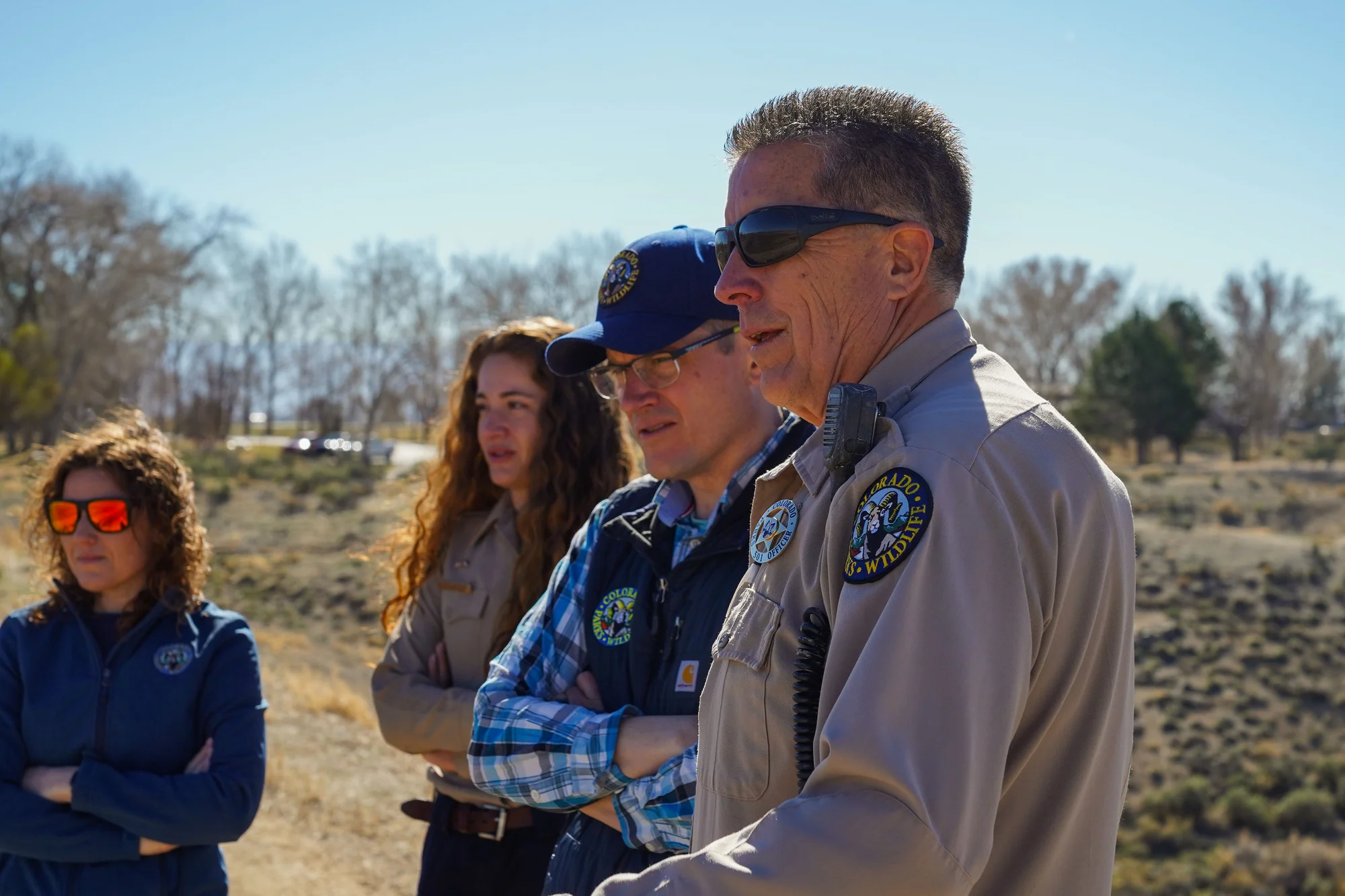 From left: CPW public information officer Rachael Gonzalez, Madeline Baker, Ben Felt, and Alan Martinez. They stand on the dam that creates Highline Lake, built in 1967. Photo: Joshua Vorse, Rocky Mountain PBS