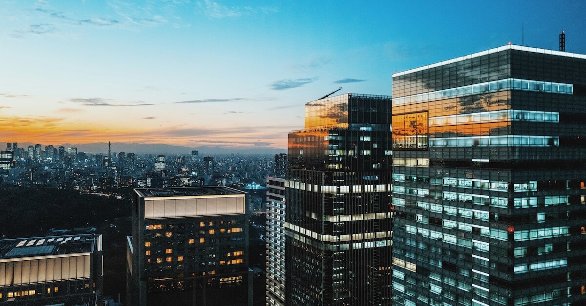 Tall buildings in a downtown area with the sunset reflecting on the windows