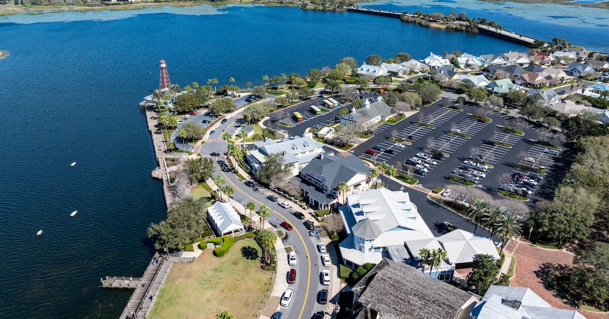 A drone view of a parking lot next to commercial property