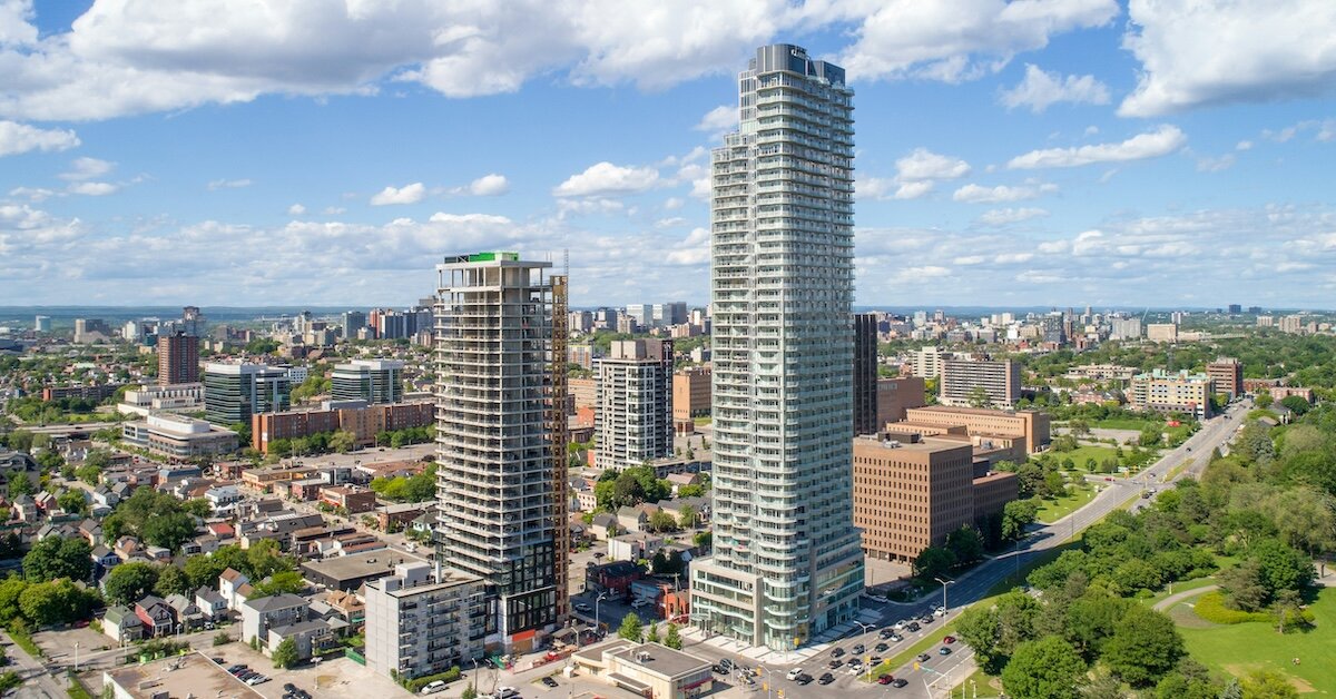 Two skyscrapers are being built among much smaller commercial real estate buildings