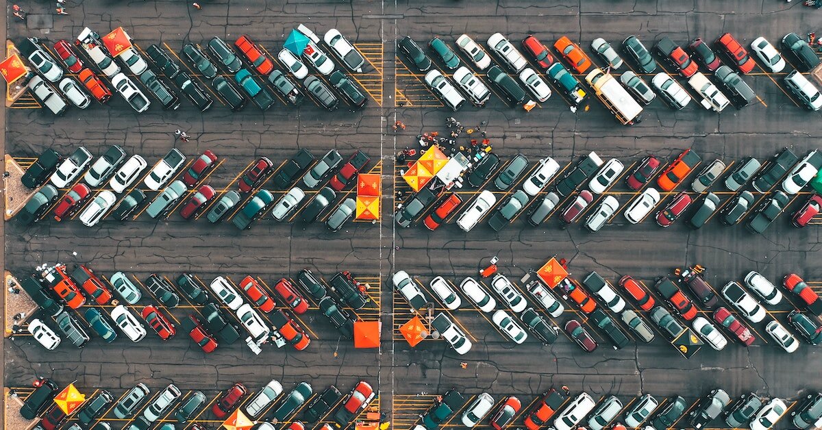 Cars parked in a parking lot sit diagonally arranged.