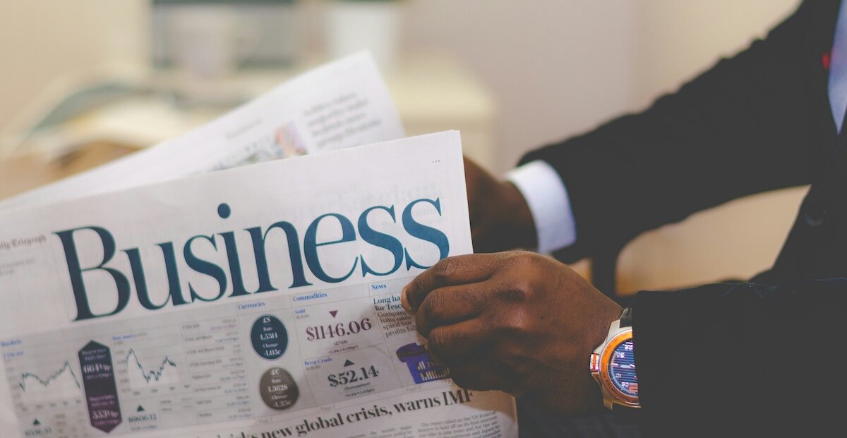 broker reading the newspaper section titled business