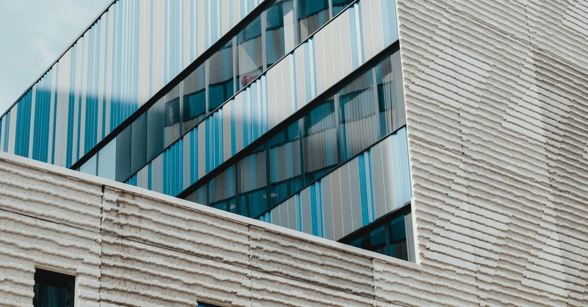 A gray apartment building with blue windows