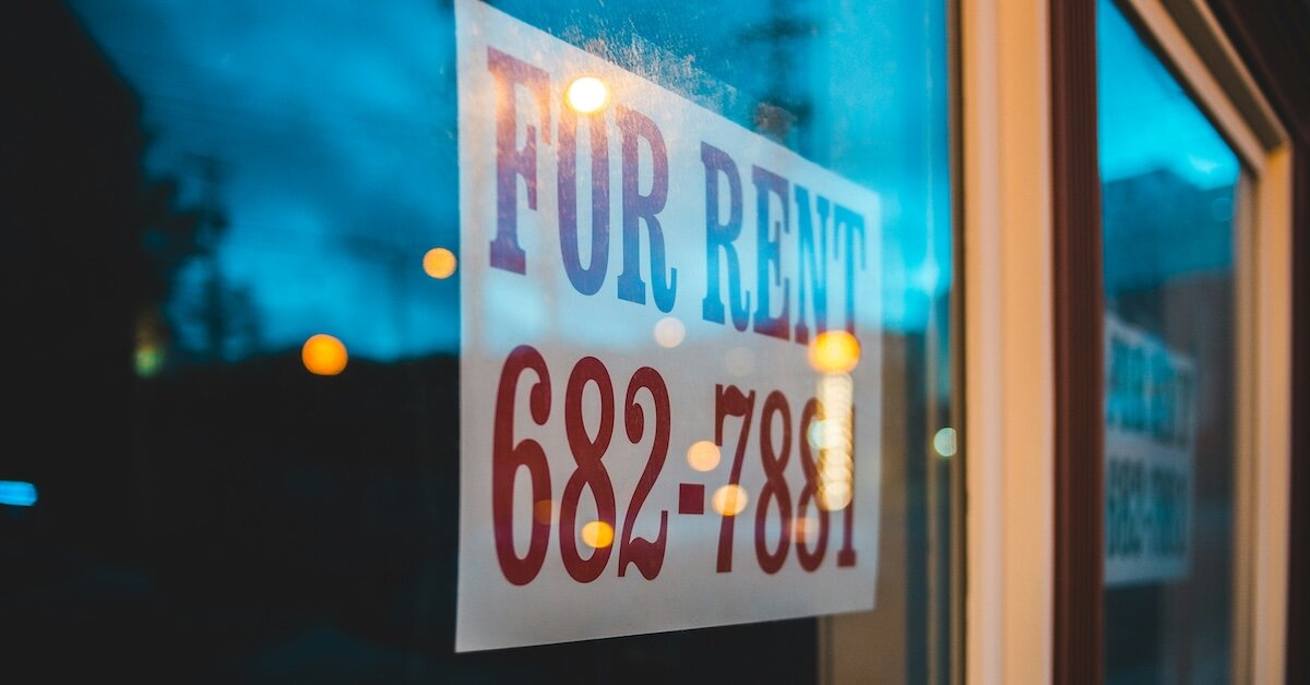 A for rent sign with a phone number in the window