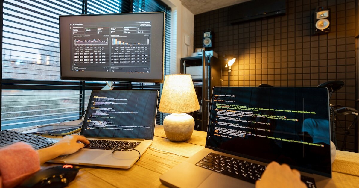 A person coding with AI on two separate computers