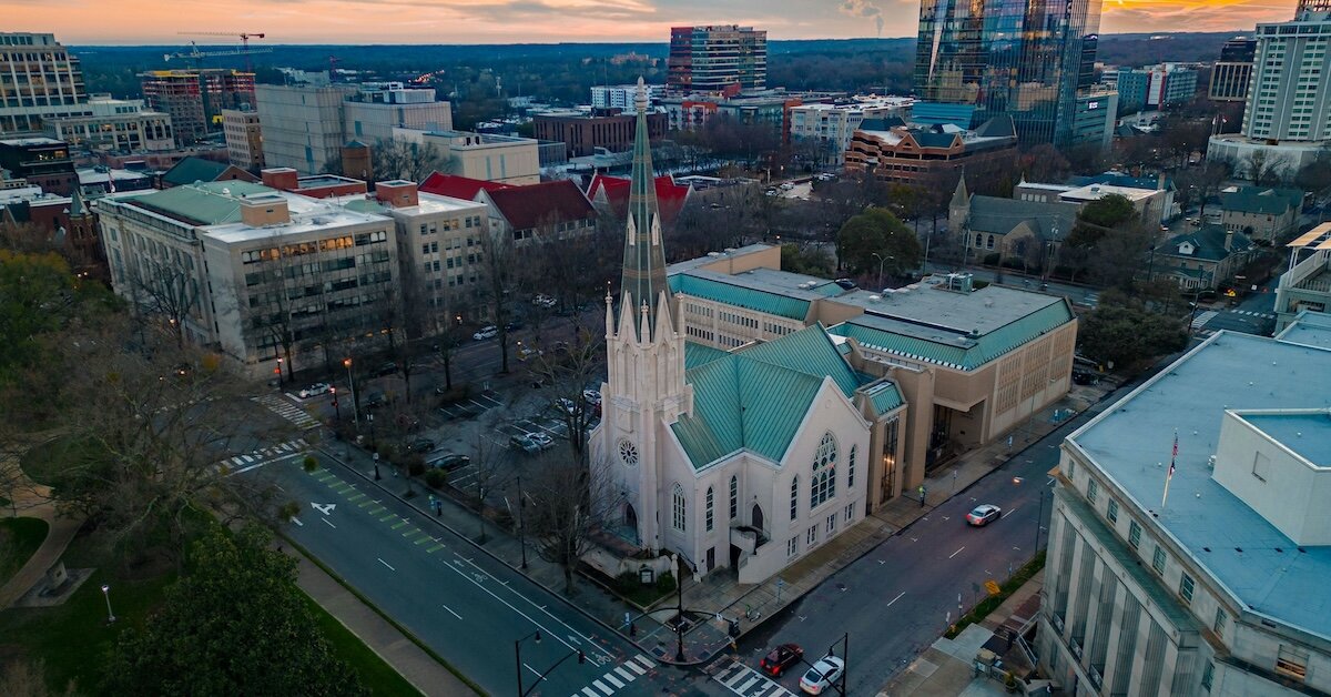 A church in Raleigh is surrounded by commercial buildings and adjacent to a vacant plot of land