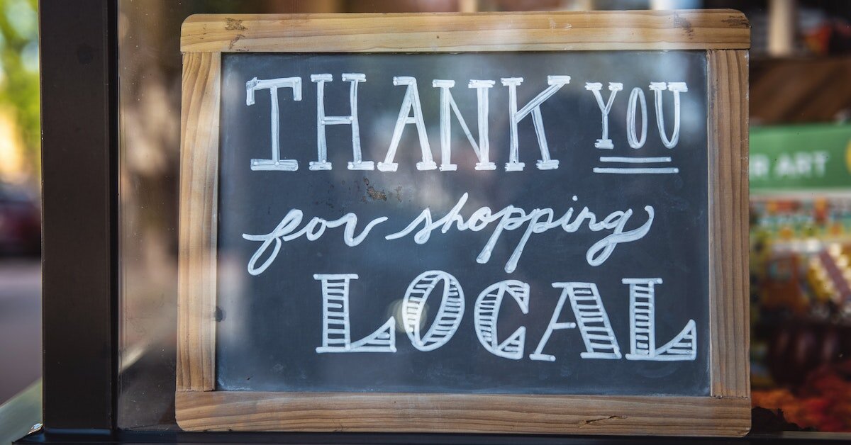 a chalkboard sign says "thank you for shopping local"