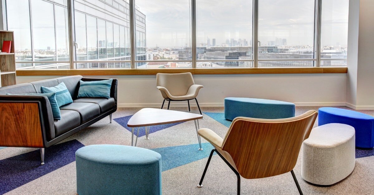 Colorful teal and cream furniture inside a communal meeting space in an office tower.