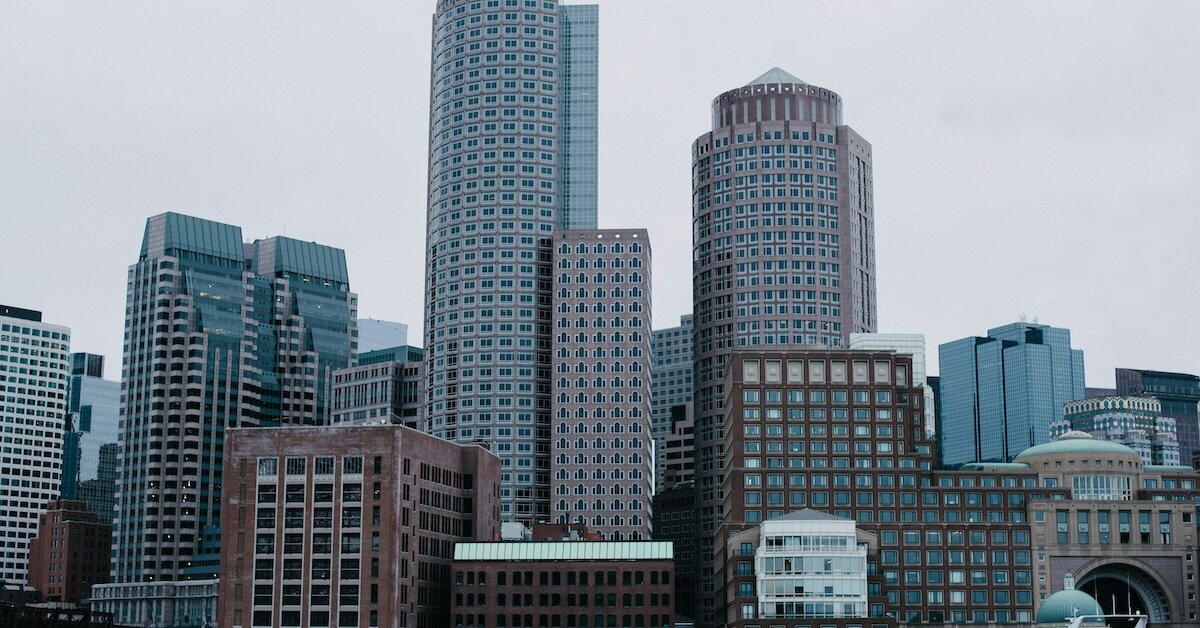 Dark blue buildings in Manhattan underneath a gray, cloudy sky