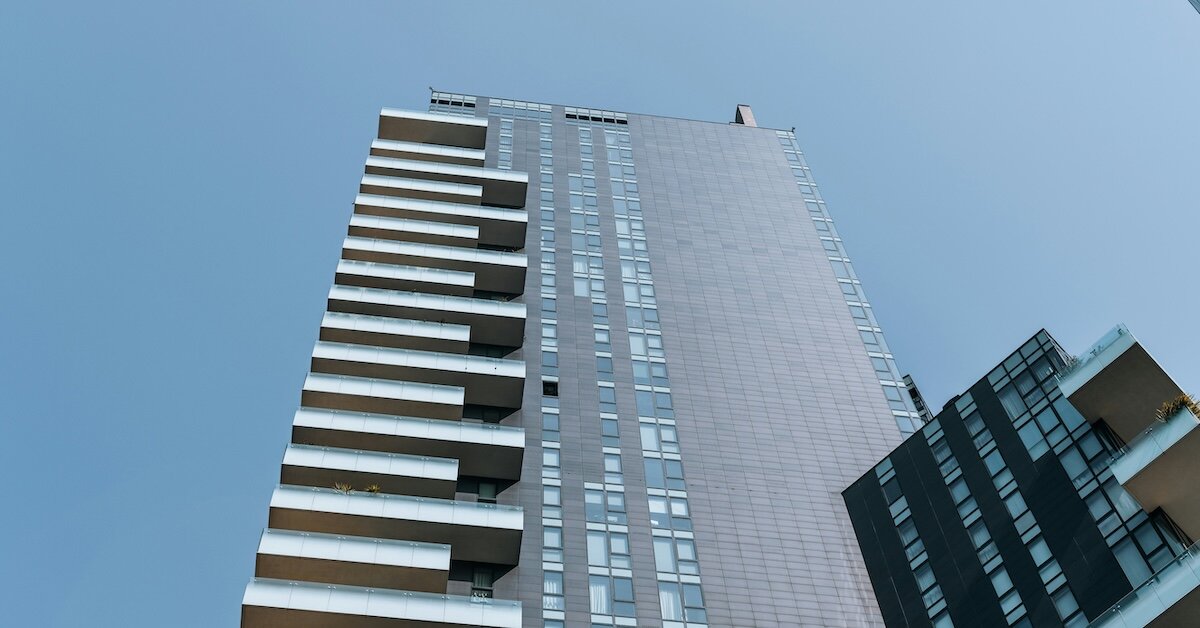 a single skyscraper stretches up into the blue sky