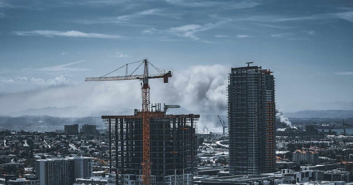 Downtown construction with smoke from a city fire in the background
