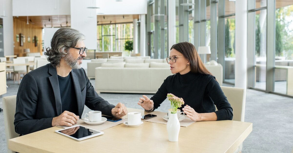 Business professionals review negotiation strategy at a shared lobby table