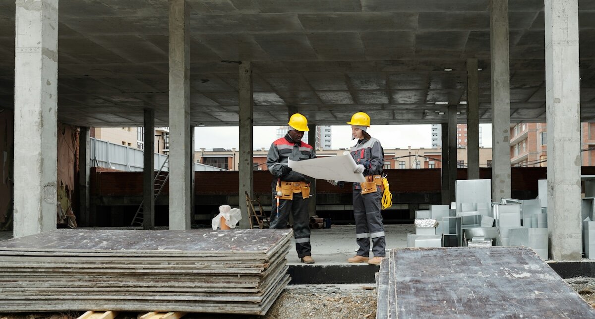 Two contractors reviewing redevelopment blueprints