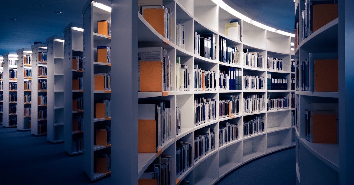 A library full of reference books and comps offers stacked shelves for research.