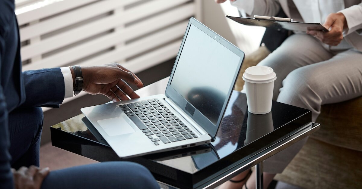 two brokers reviewing business things on a laptop