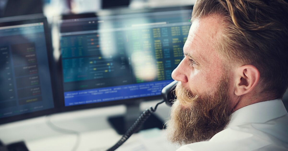 A broker on phone call tracks lead lists on his computer