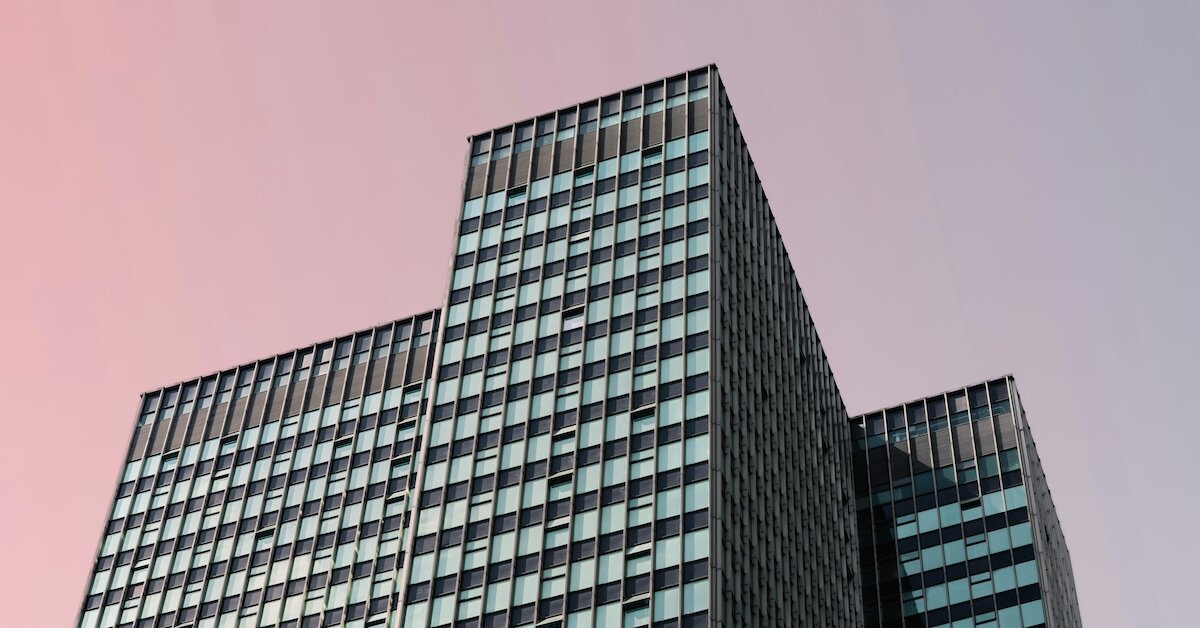 a lit up building against a dusky pink sky