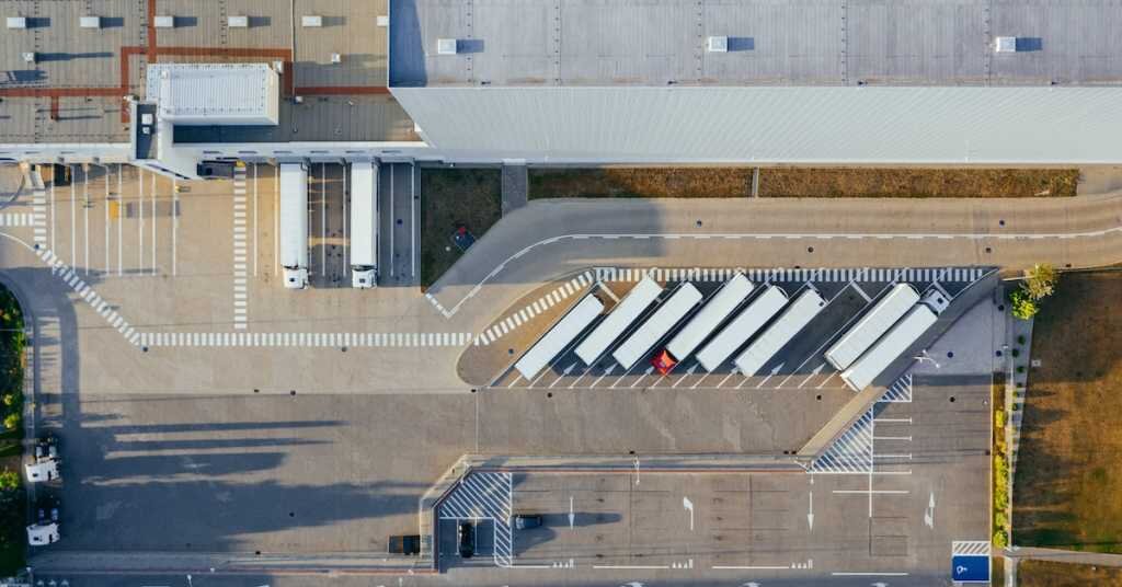 trucks in a parking lot waiting to load at a warehouse loading dock