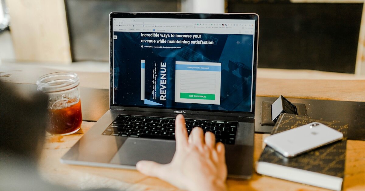 A person reviews a revenue and income related page on their laptop