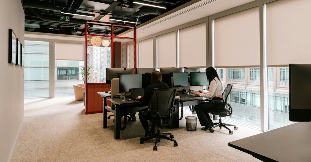 An office worker sits at desk in a small bullpen