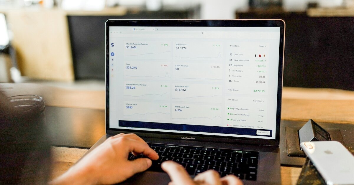 a person types on their computer, looking at a dashboard of different data points