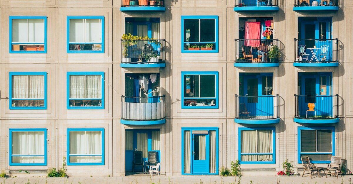 Blue-lined multifamily apartment windows with various balcony decorations